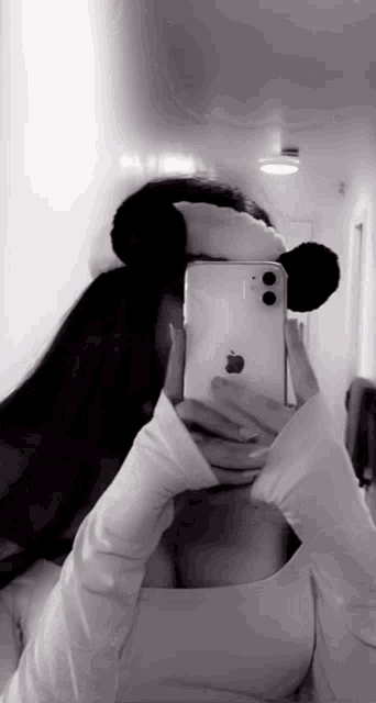 a woman is taking a picture of herself in a mirror with her iphone