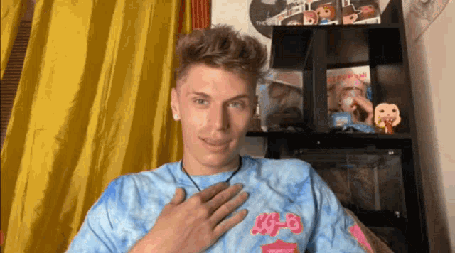 a man wearing a blue tie dye shirt that says r.e.a.