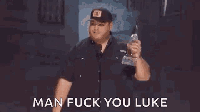 a man is standing in front of a microphone holding a can of beer and a glass of water .