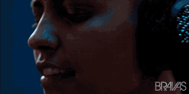 a close up of a woman wearing headphones with the word bravas on the bottom