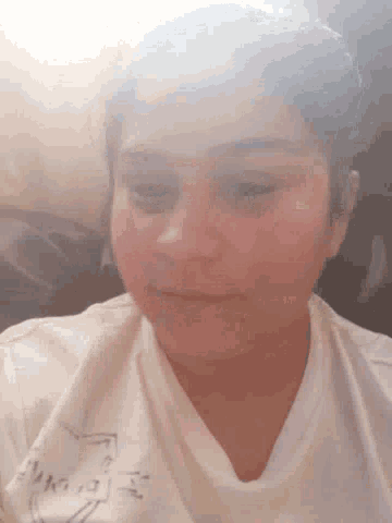 a woman in a white shirt is smiling while laying on her back .