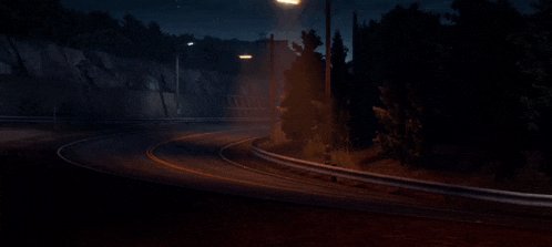 a car is driving down a road at night