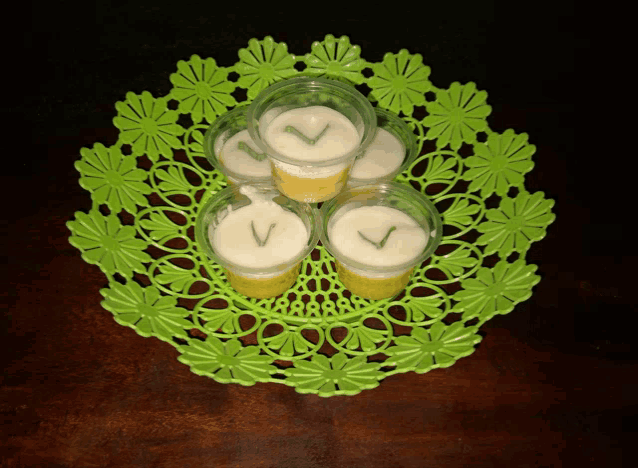a green place mat with a few cups of food on top of it