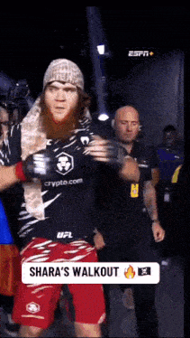 a man wearing a black shirt that says crypto.com walks out of the ring