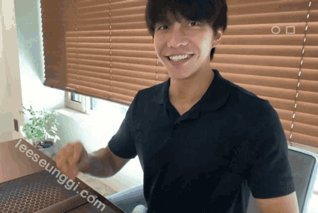 a man is smiling in front of a window with blinds and the website leeseunggi.com is visible