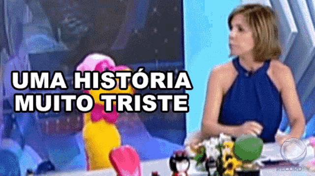 a woman is sitting at a table with a stuffed animal and the words uma historia muito triste written above her