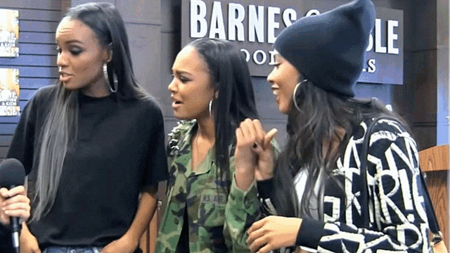 three women standing in front of a sign that says barnes and noble