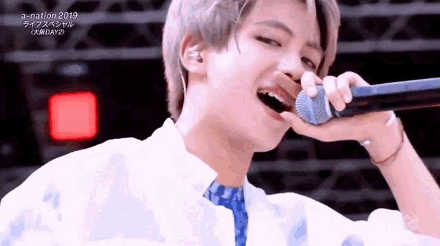 a close up of a person singing into a microphone with the year 2019 on the bottom