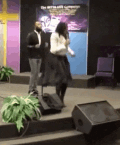 a man and a woman are standing on a stage in front of a sign that says " the matta art company "