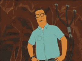 a man with glasses and a blue shirt is standing with his hands on his hips