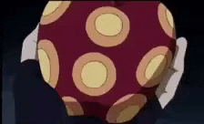 a person is holding a red ball with yellow circles on it in their hands .
