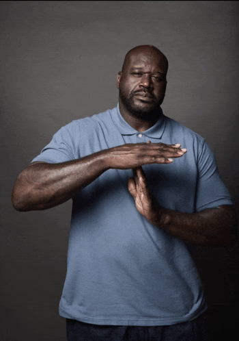 a man in a blue shirt is making a stop gesture with his hands