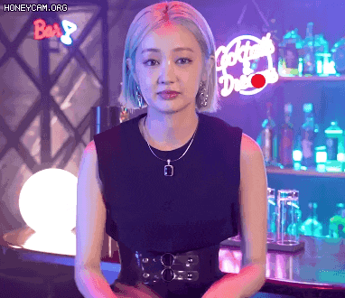 a woman in a black dress is standing in front of a bar with a sign that says cocktails on it