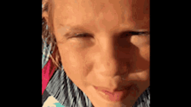 a close up of a young girl 's face with her eyes closed .