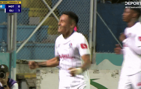 a soccer player celebrates a goal in front of a scoreboard that says mot on it