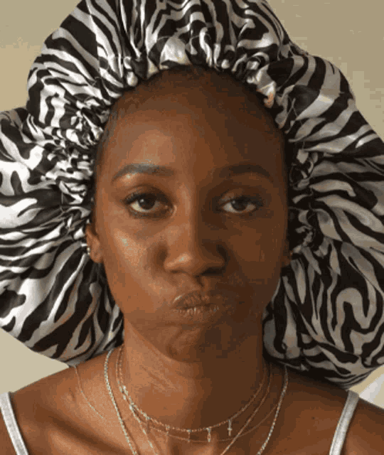 a woman wearing a zebra print bonnet makes a face