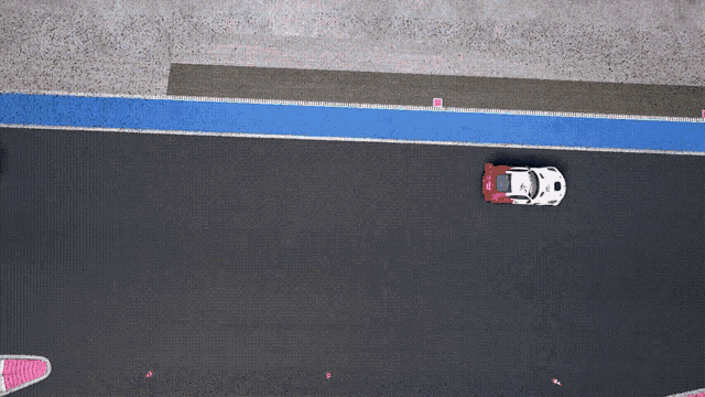 an aerial view of a race track with a red and white race car