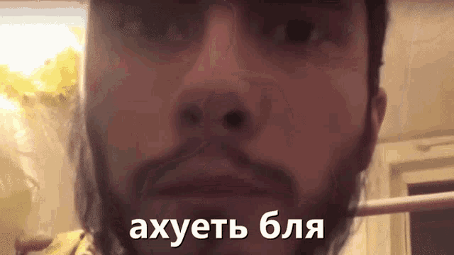 a close up of a man 's face with a foreign language behind him