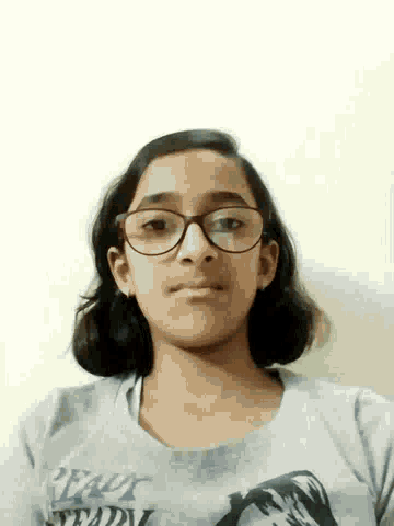 a girl wearing glasses and a shirt that says " tractor " on it