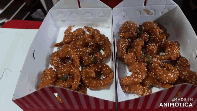 two boxes of fried chicken with sesame seeds and a made in animatica logo