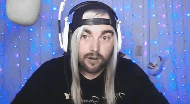 a man with a beard wearing headphones and a wig that says ' a ' on it