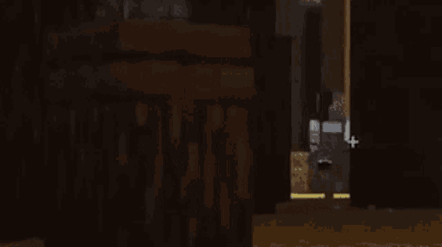 a person is standing in a dark room next to a wooden fence in a video game .