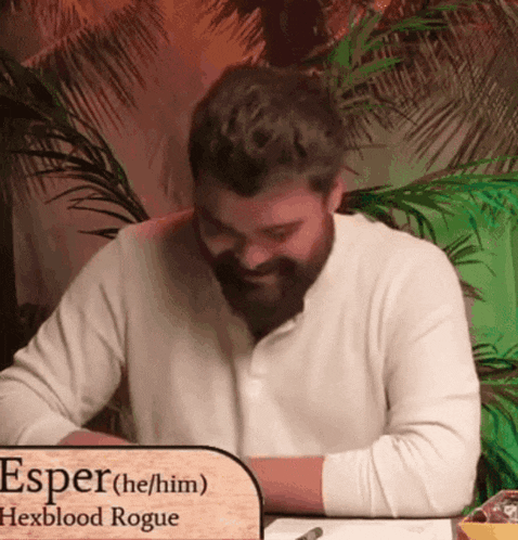 a man sitting at a table with a sign that says " esper "