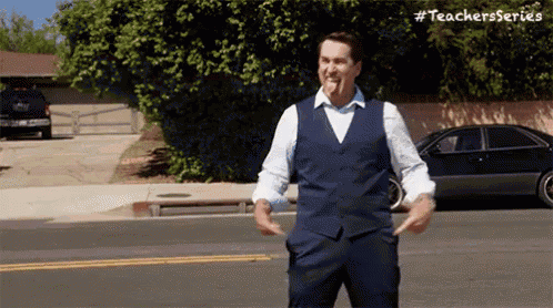 a man in a suit is standing on the side of the road .