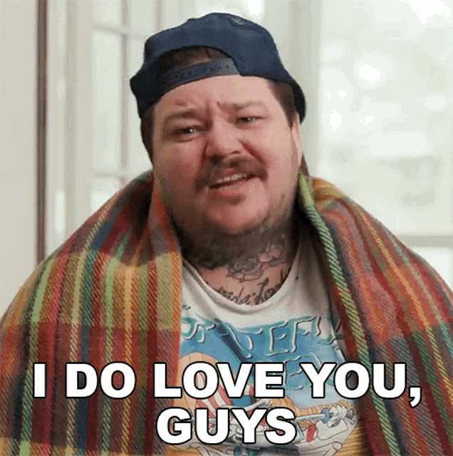 a man is wrapped in a plaid blanket and says i do love you guys