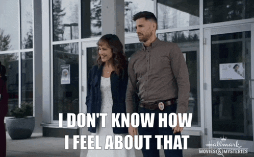a man and a woman standing in front of a building with the words i don 't know how i feel