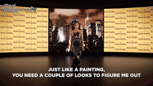 a woman in a black dress is standing in front of a wall that says raquel on it