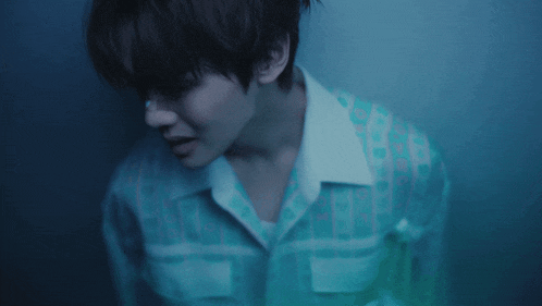 a close up of a man 's face with a blue shirt on