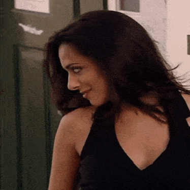 a woman in a black dress is standing in front of a door