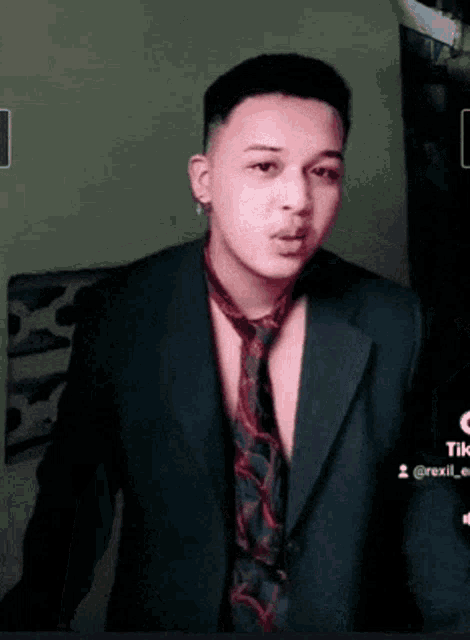 a man wearing a suit and tie has a tiktok account
