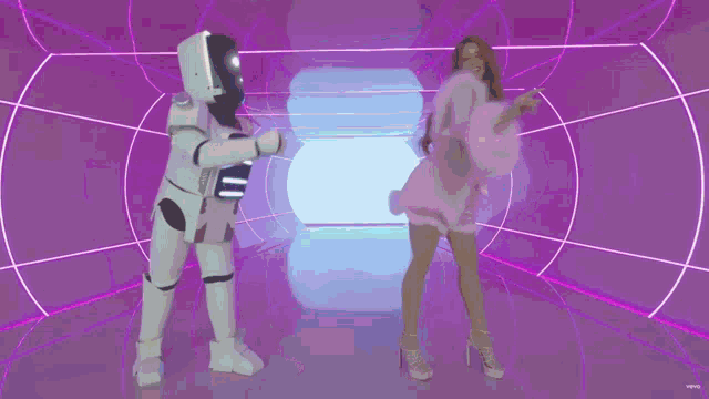 a woman in a pink dress is dancing next to a white robot