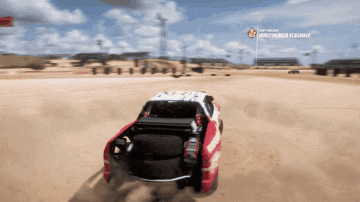 a red and white truck is driving through the desert with a sign that says " i am racing "