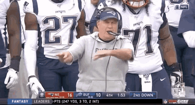 a man in a patriots jersey stands in front of a group of football players
