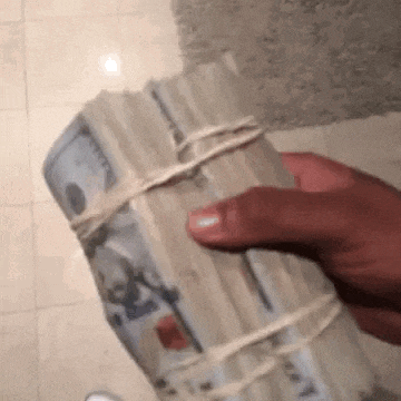 a person is holding a stack of money wrapped in string .