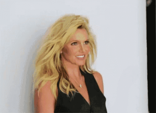 britney spears is wearing a black dress and a necklace .