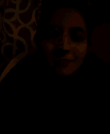 a close up of a person 's face with their mouth open in the dark