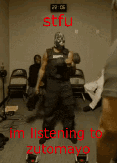 a man wearing boxing gloves is standing in front of a clock that says 22:05 on it