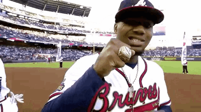a man wearing a braves jersey and a ring on his finger