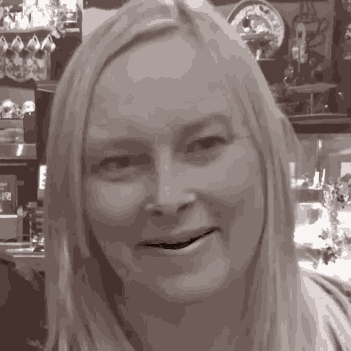 a black and white photo of a woman smiling with a clock in the background