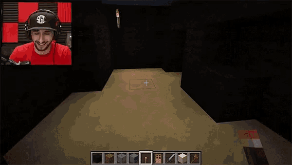 a man wearing headphones is playing a video game called minecraft