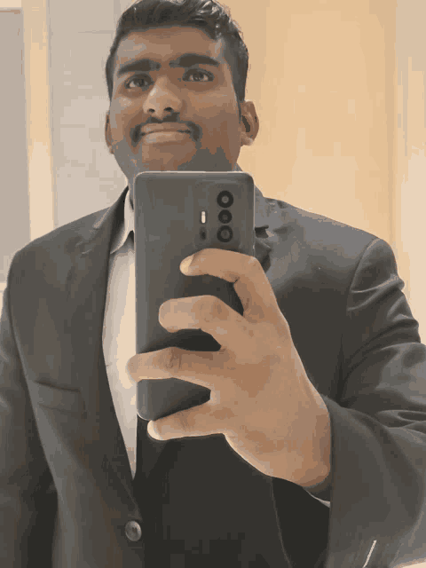 a man in a suit is taking a picture of himself with his phone