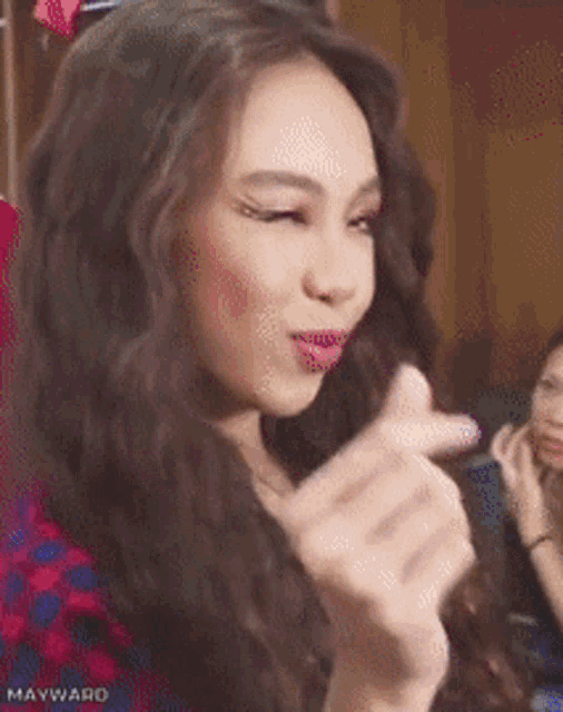 a woman in a plaid shirt is making a funny face with her finger in her mouth