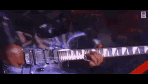 a close up of a person playing a guitar in a dark room