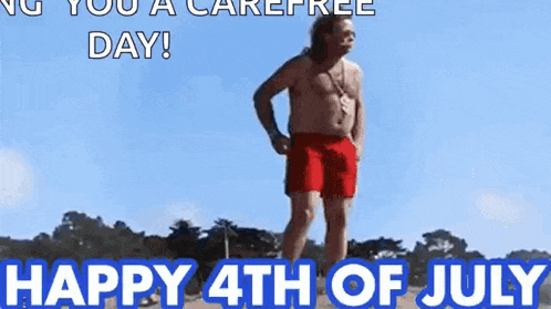 a shirtless man in red shorts is standing on a beach with the words `` happy 4th of july '' .