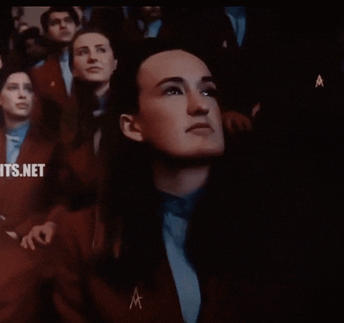 a group of people are sitting in a dark room with the words its.net on the bottom right