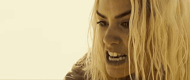 a close up of a woman 's face with a very angry look on her face .